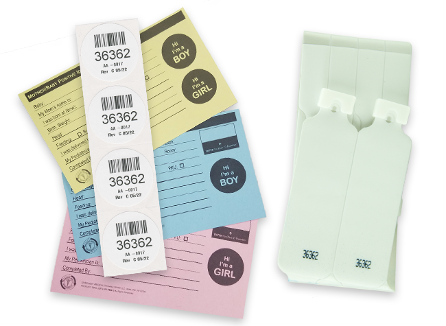 set of 3 crib cards in pink blue and yellow underneath a column of round numbered stick-on identification labels, all next to a set of patient id bands